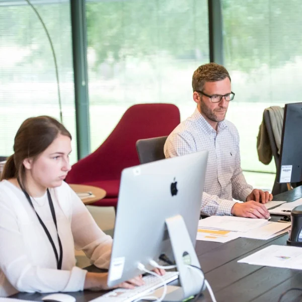 A diverse team collaborating at a desk in an office, focused on BPO services and enhancing productivity.