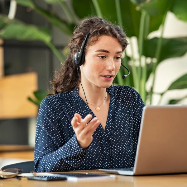 A woman in a headset engaged in a phone conversation, representing remote customer service support.