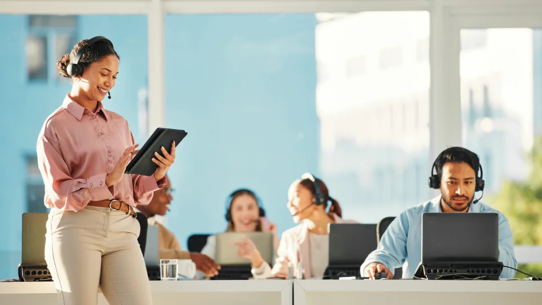 A woman in a call center, focused on her laptop, exemplifying a professional contact center experience.